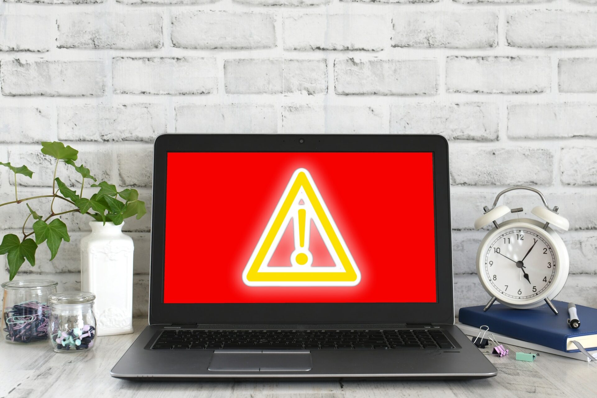 Computer screen showing red screen with yellow glowing danger sign. Concept hack virus cyber attack