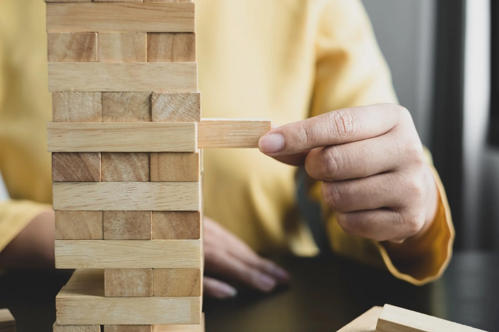 Hands of businesswomen playing wooden block game. Concept Risk of management and strategy plans for