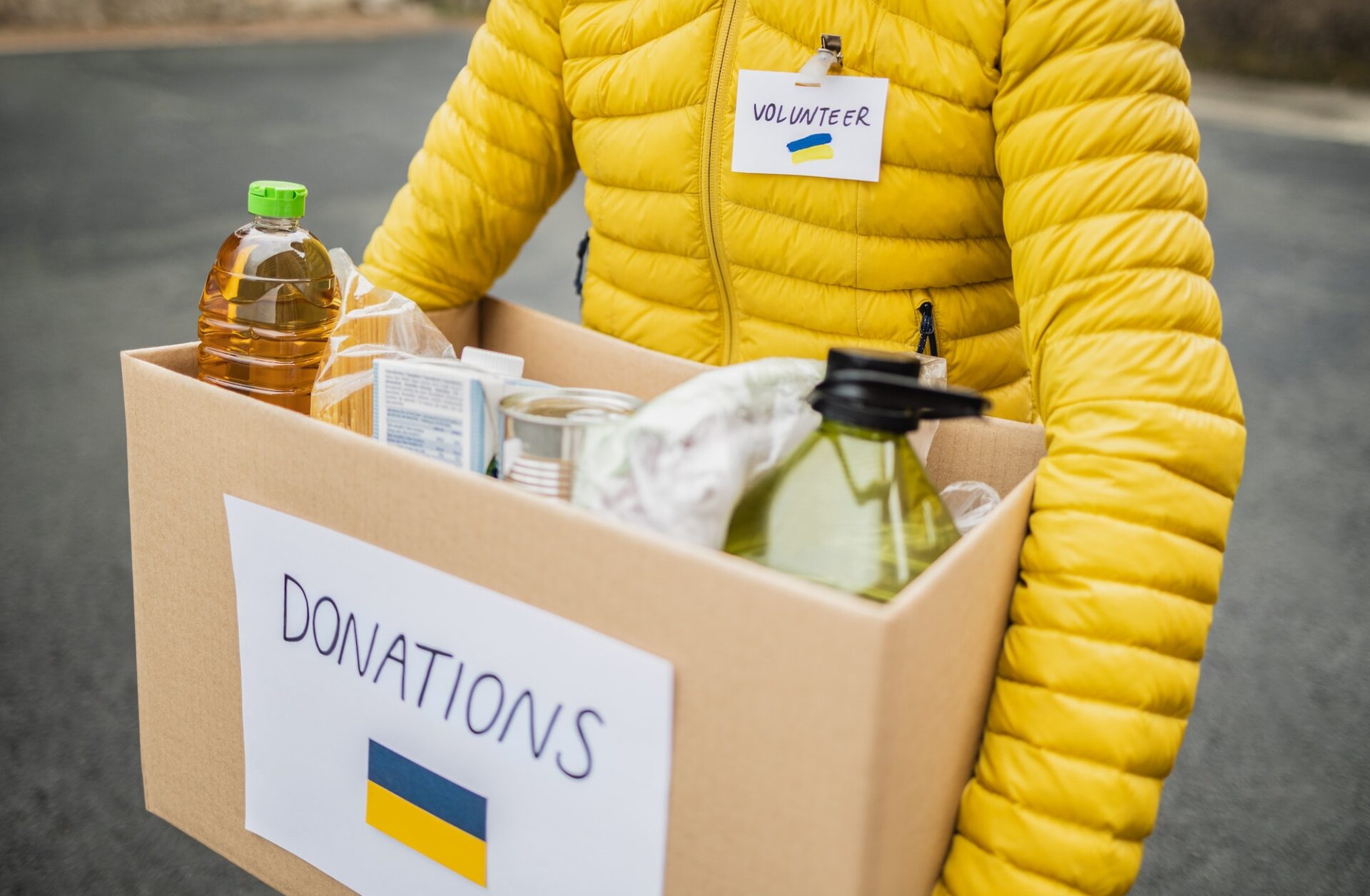 Volunteer collecting box with donations for Ukrainian refugees - Humanitarian aid for Ukraine