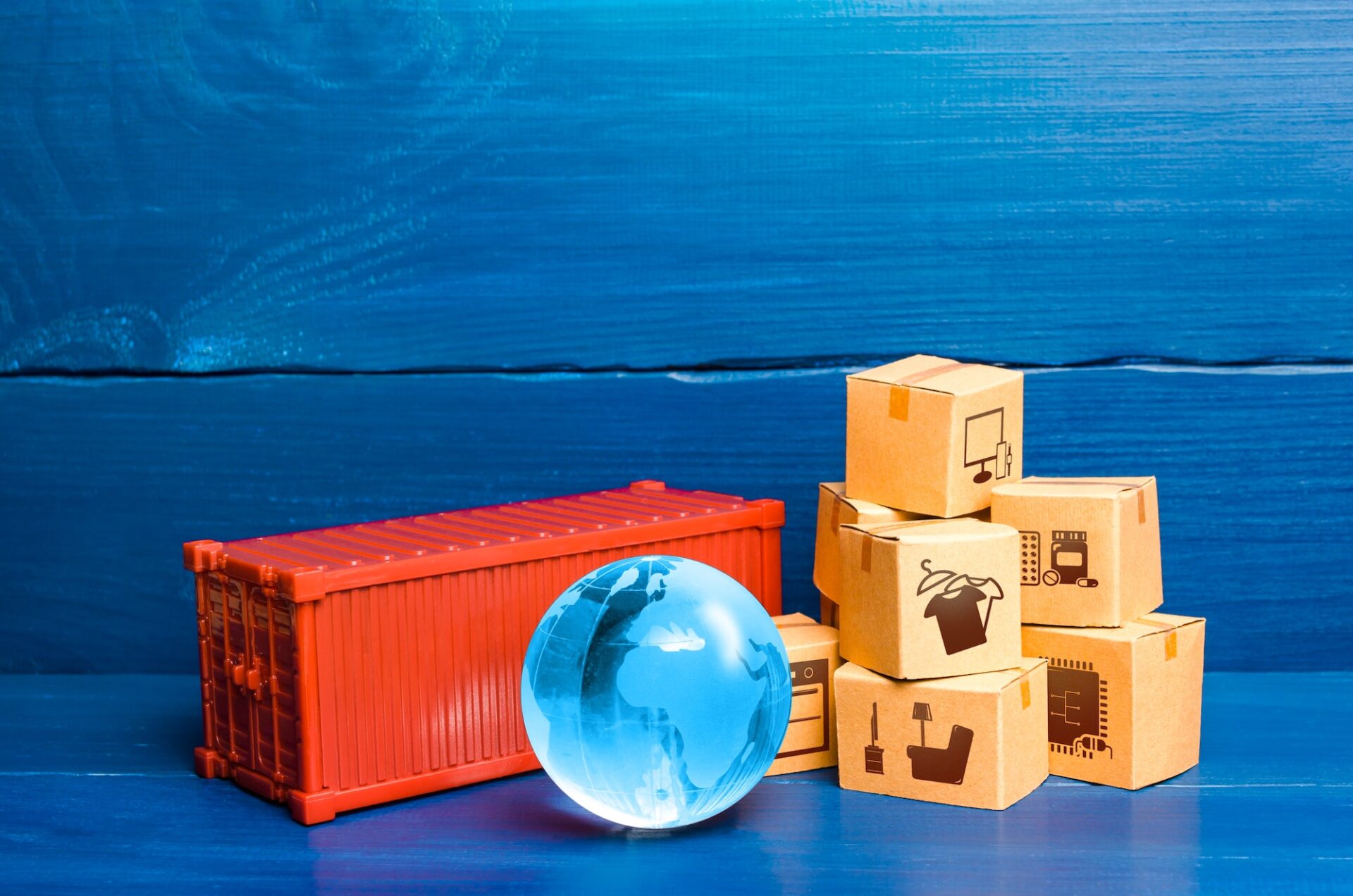 Red cargo container with boxes and blue globe of planet Earth. Global international trade in goods