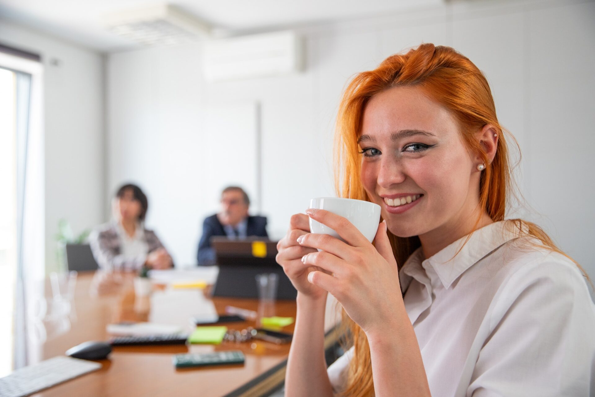 A businesswoman relaxes in the office drinking coffee, wellbeing at work concept