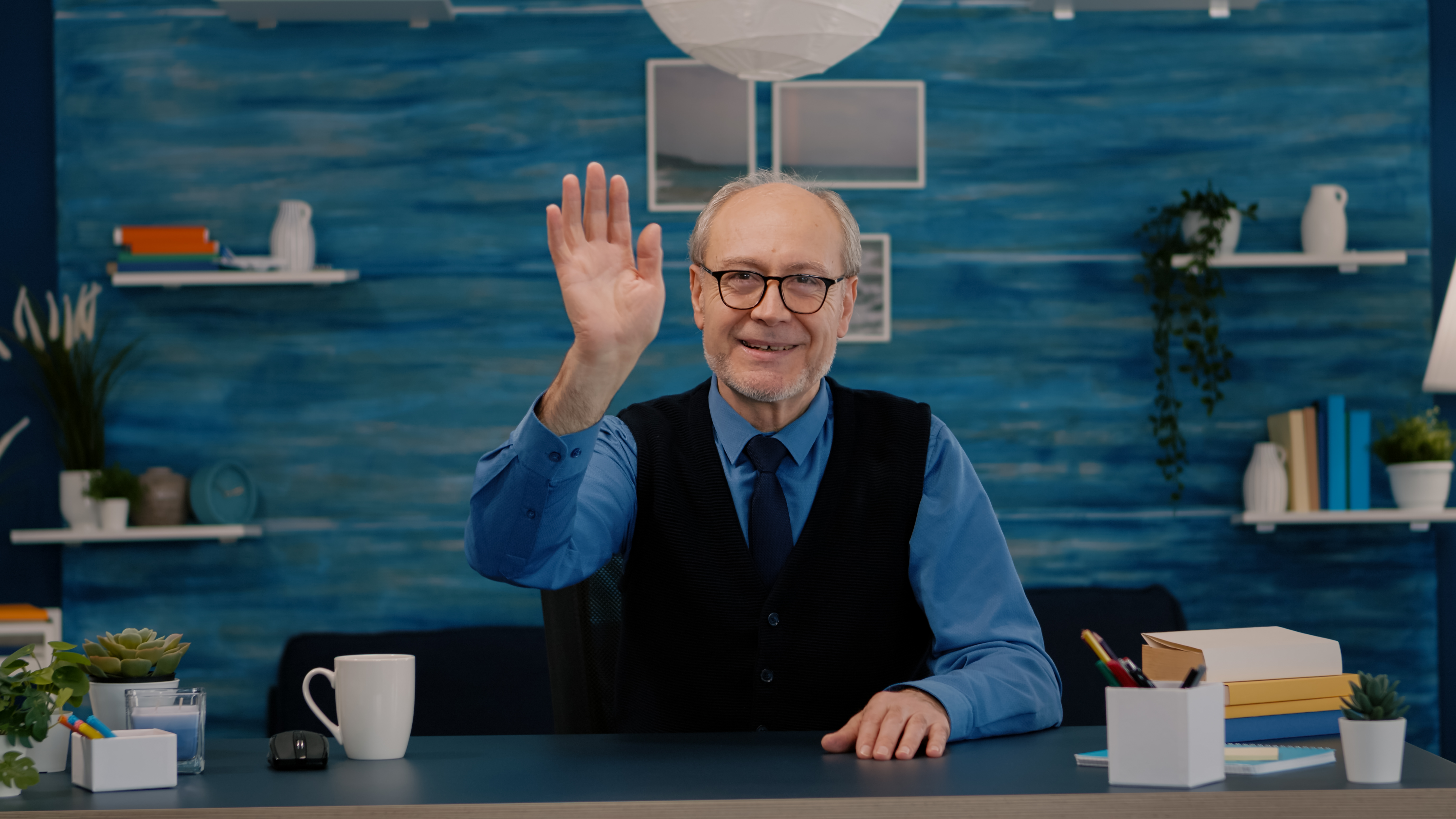 POV of elderly aged man waving during a video conference