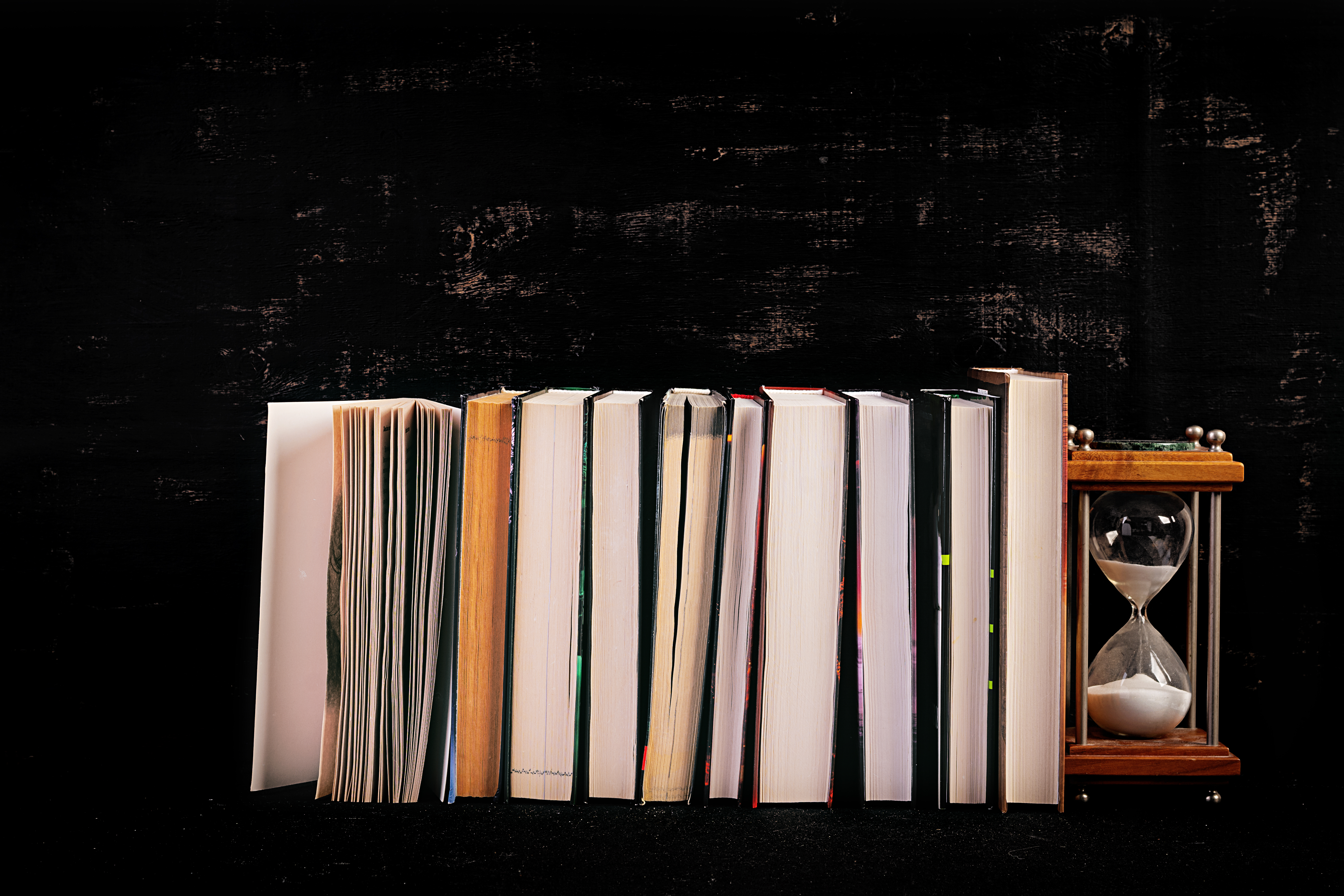 Stack of different books on dark background. Knowledge concept.