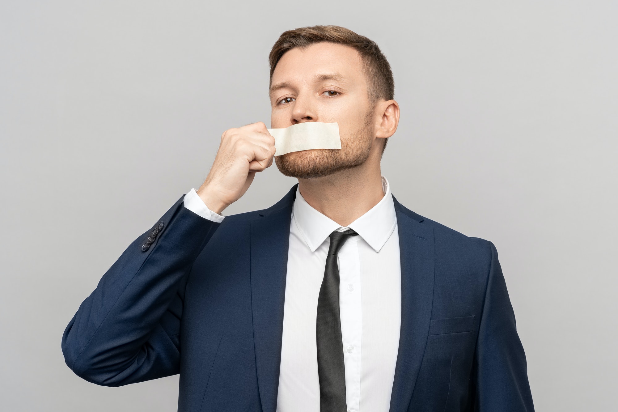 Man office worker with tape on his mouth. Prohibitions of expression opinion, freedom of speech