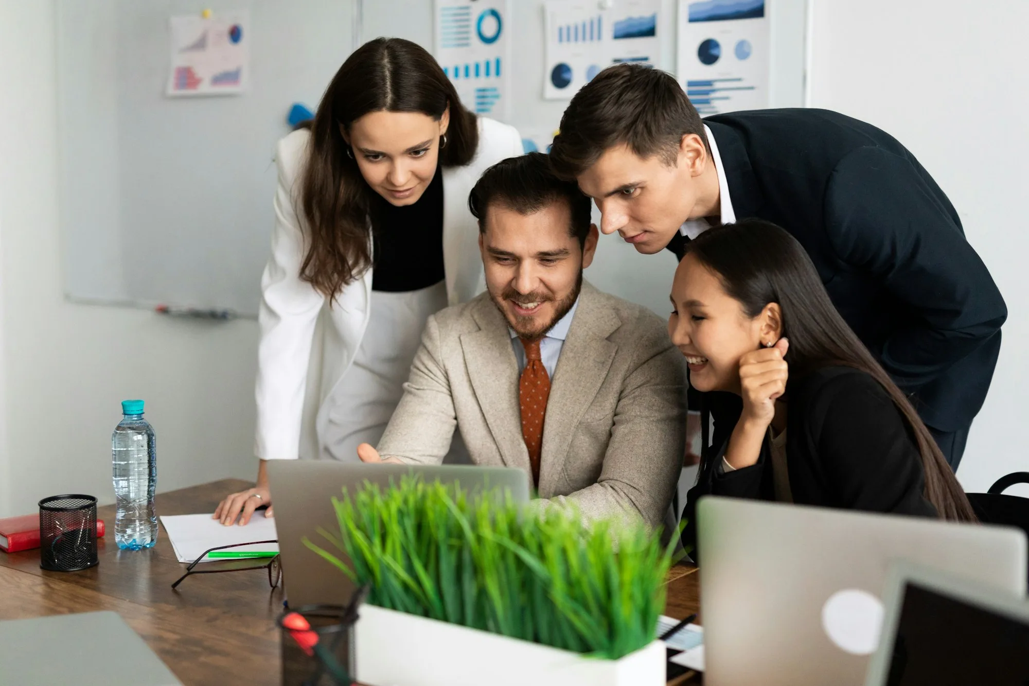 business people of different nationalities and different genders at a laptop jointly solve a problem