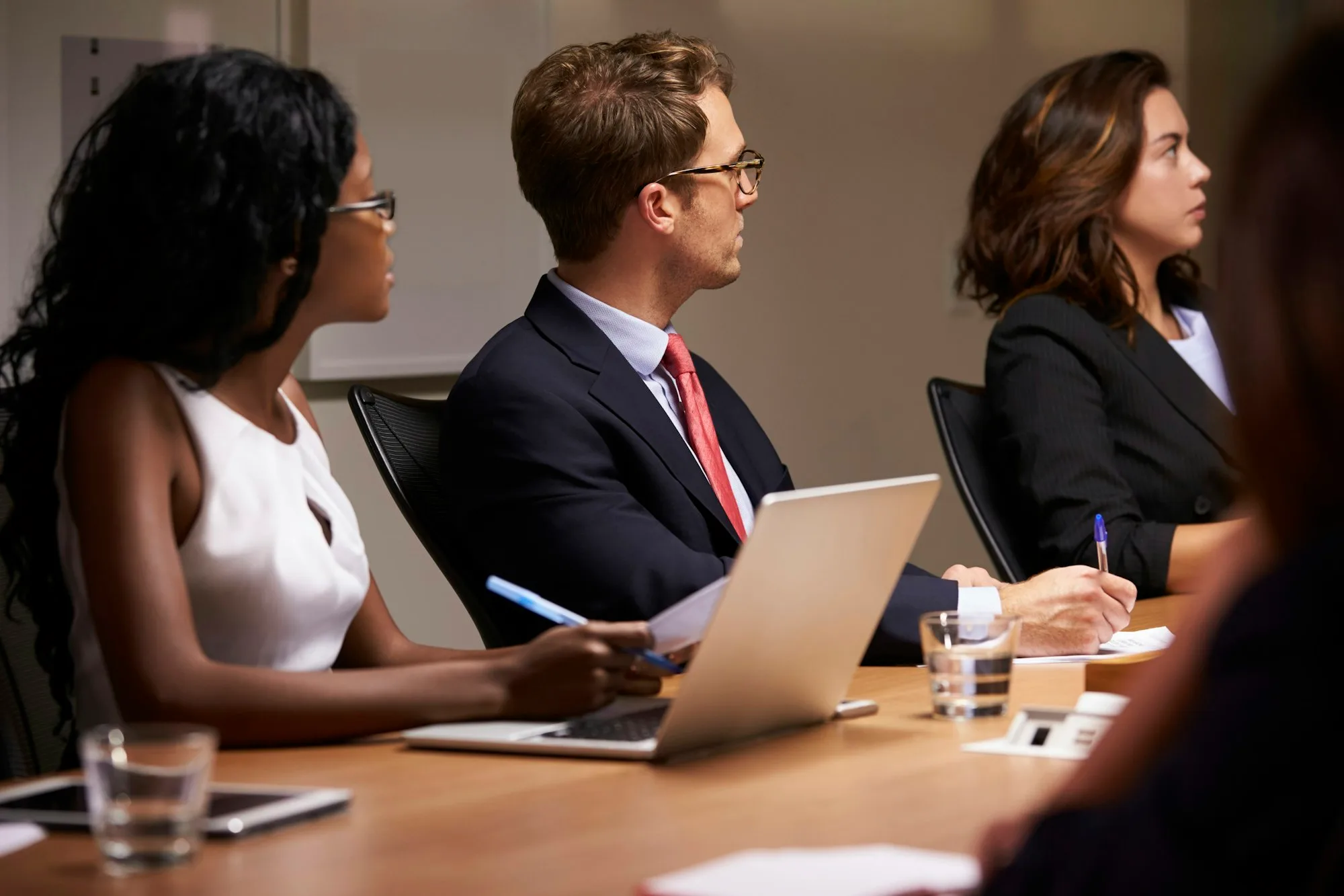 Business colleagues listening at boardroom meeting